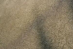 Sun shining on a cement wall background, grungy shiny wall surface, rusty cement wall backdrop photo