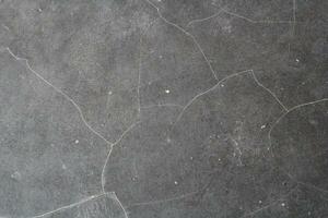 Dark cracked floor surface, shiny deep dark background, grungy floor background photo