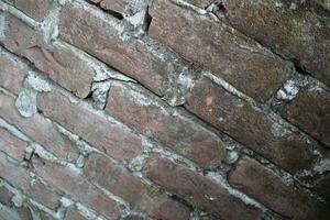 Weathered brick layer wall background, grungy brick texture surface, aged wall texture photo
