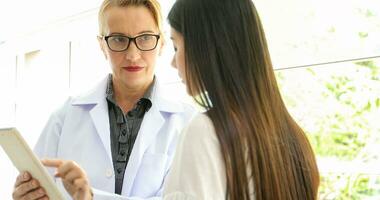 Asian woman patient sitting with doctor about her illness and showing x-ray results photo