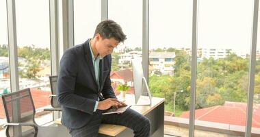 empresario utilizando ordenador portátil y contemplando mientras trabajando a su escritorio en el oficina. foto