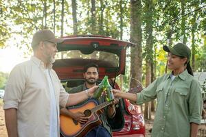 Group tourists drinking beer-alcohol and play guitar together with enjoy and happiness in Summer while camping photo