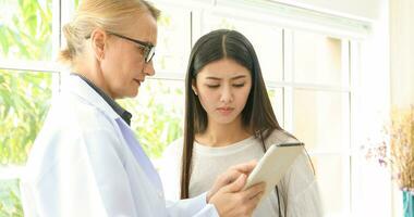 Asian woman patient sitting with doctor about her illness and showing x-ray results photo