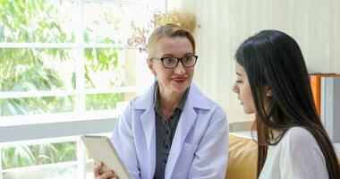 asiático mujer paciente sentado con médico acerca de su enfermedad y demostración radiografía resultados foto