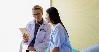 Asian woman patient sitting with doctor about her illness and showing x-ray results with blood pressure and heart rate measurement with stethoscope photo