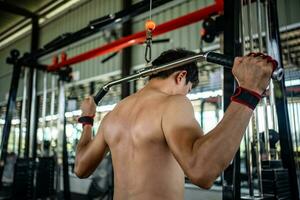 Man doing squat exercises with a barbell in gym photo