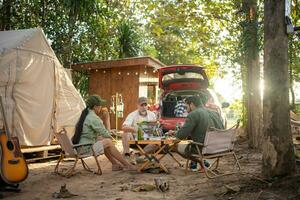 Group tourists drinking beer-alcohol and play guitar together with enjoy and happiness in Summer while camping photo