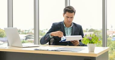 businessman using laptop and contemplating while working at his desk in the office. photo