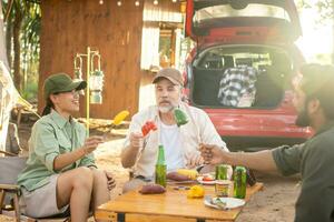 Group tourists drinking beer-alcohol and play guitar together with enjoy and happiness in Summer while camping photo