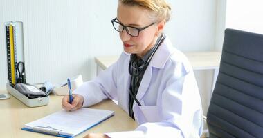 Asian woman patient sitting with doctor about her illness and showing x-ray results with blood pressure and heart rate measurement with stethoscope photo