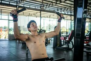 Man doing squat exercises with a barbell in gym photo