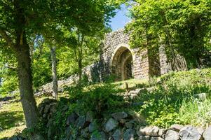 the ruins of an old stone building in the woods photo