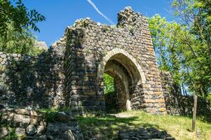 a stone archway in the woods photo