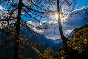 the sun shines through the clouds over a mountain range photo