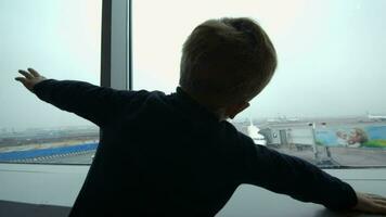 Boy looking at the plane from window and imitating it video