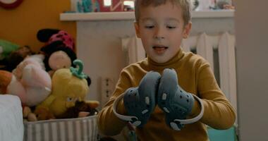 Boy putting on shoes on hands and clapping video