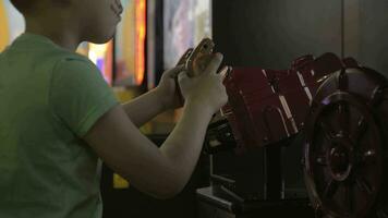 A boy playing in a game zone on a game machine video