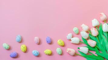 colorful easter eggs and tulips on pink background photo