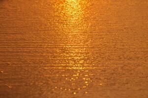 borroso antecedentes de superficie agua en el puesta de sol hora foto