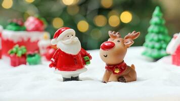ciervos lluvia y Papa Noel claus en el pueblo con brillante ligero para Navidad decoración foto
