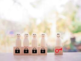 Wooden figure standing on wooden block of key and padlock. Key for finding solutions concept, business problem solving. Keys unlocking to achieve goals and mission. photo