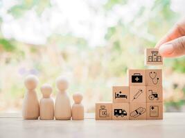 Close up hand arranging wooden block with health care and medical icons set and wooden human figure photo