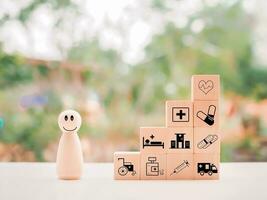 Wooden human figure and wooden block with health care and medical icons set. photo