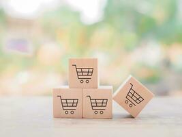 Wooden block with shopping cart icons for online shopping and e-commerce concept photo