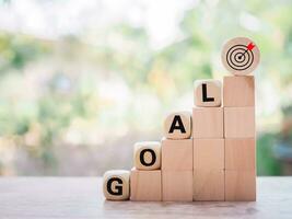 Wooden blocks with the word GOAL and business strategy icons for success and winner concept photo