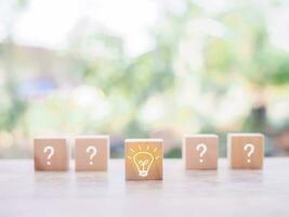 Wooden block with light bulb and wooden block with question mark for leadership, creative, idea, innovation concept. photo