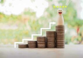 Wooden business figure with happy face and 5 star standing on stack of coins for leader teamwork power and confidnce, Successful team leader concept. photo