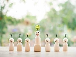 Wooden business figure with light bulb and question mark for leadership, creative, idea, innovation concept. photo