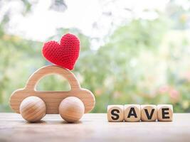 Wooden toy car and wooden blocks with the word SAVE. The concept of saving for car. photo