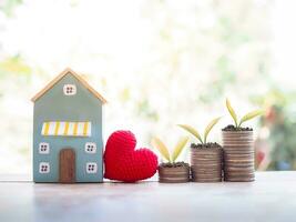 Plants growing up on stack of coins for Investment property concept. Saving money for buy a house. photo