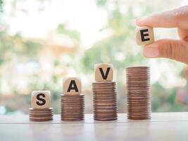 Wooden blocks with the word SAVE on stack of coins, The concept of save money for prepare in the future. photo