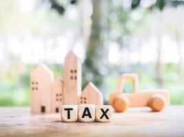 Wooden blocks with the word TAX, The concept of paying tax for house or property and car photo