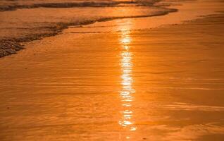 agua y arena a el playa en puesta de sol hora foto