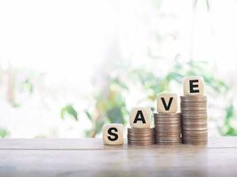 Wooden blocks with the word SAVE on stack of coins, The concept of save money for prepare in the future. photo