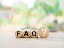 Wooden block with word the FAQ with question marks. The concept of question or answer time. photo