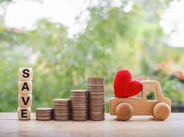 Wooden toy car, stack of coins and wooden blocks with the word SAVE. The concept of saving for car. photo