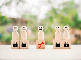 Wooden figure standing on wooden block of key and padlock. Key for finding solutions concept, business problem solving. Keys unlocking to achieve goals and mission. photo