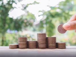 Close up hand putting coin in stack of coins, The concept of save money for prepare in the future. photo