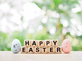 Wooden block with word HAPPY EASTER with colorful eggs for Easter day concept. photo