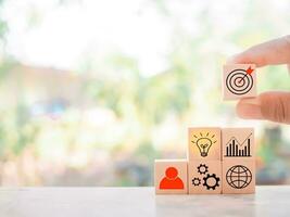 cerca arriba mano arreglando de madera bloquear con negocio estrategia iconos, acción plan y negocio proceso administración concepto. foto