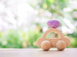 Wooden toy car with Easter eggs for EASTER DAY concept. photo