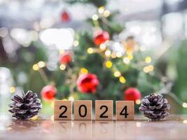 cerca arriba de número 2024 y piñas con Navidad ligero bokeh antecedentes. alegre Navidad y contento nuevo año 2024 foto