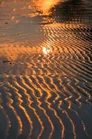 Water and sand at the beach in sunset time photo