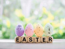 Wooden block with word HAPPY EASTER with colorful eggs for Easter day concept. photo