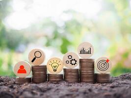 wooden block with  business strategy icons on stack of coins, Action plan and business process management concept. photo