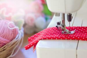 Close up of sewing machine working with red fabric photo